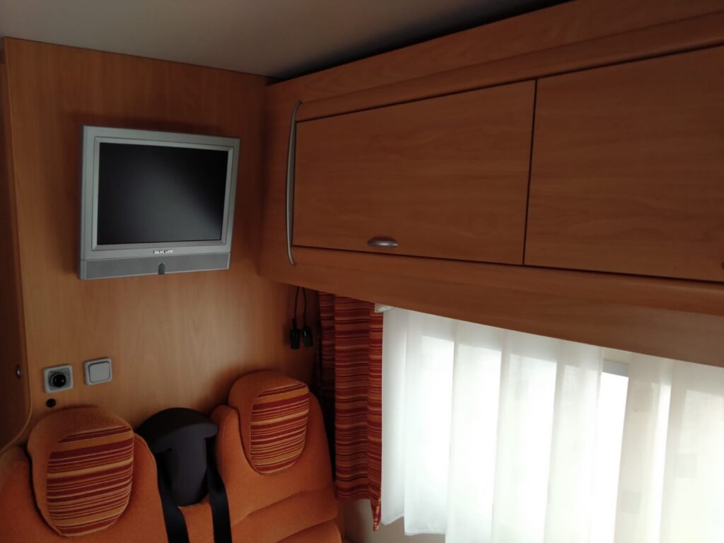 interior con televisión y muebles superiores de autocaravana de alquiler en vigo